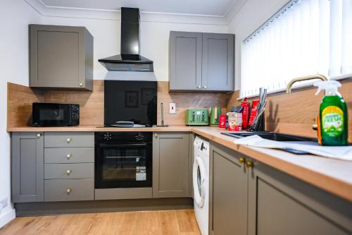 a kitchen with a sink and a stove top oven at Elm House in Bathgate