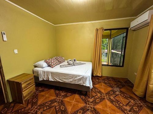 a bedroom with a bed with a stuffed animal on it at Cabaña La Conquista Naturaleza aves y tranquilidad en Sarapiquí cerca de la Selva in Sarapiquí
