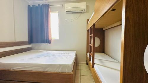 a small room with two bunk beds and a window at Thermas Paradise Apartamentos Rio Quente Esplanada in Rio Quente