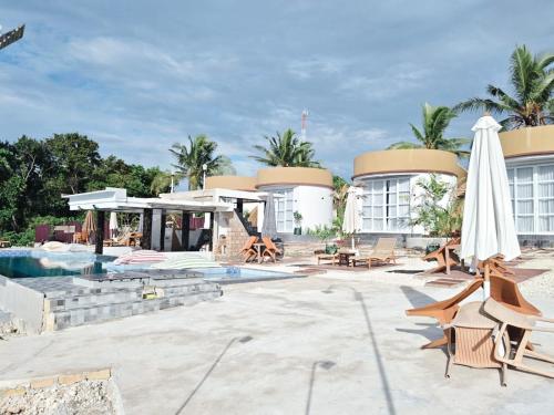 a resort with a pool and an umbrella and chairs at Viera Resort in Ngurblut