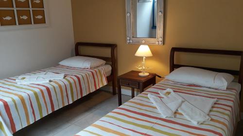 twee bedden naast elkaar in een kamer bij Pousada Flor do Mar in Paraty