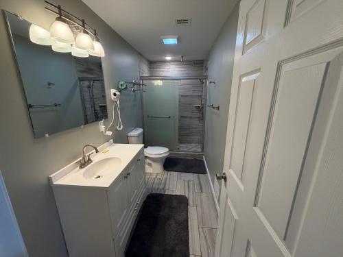 een badkamer met een wastafel, een toilet en een spiegel bij Anchor Motel in Seaside Heights