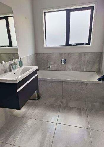 a bathroom with a sink and a bath tub and a window at Great getaway in Picton