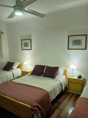 a hotel room with two beds and two lamps at Hotel Ancon in Buenos Aires