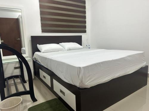 a bed with white sheets and pillows in a bedroom at Oval View Residencies By C in Colombo