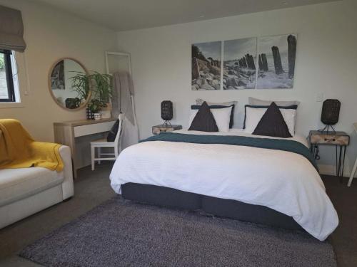 a bedroom with a large bed and a couch at 54 on Charles at Westshore NAPIER in Napier