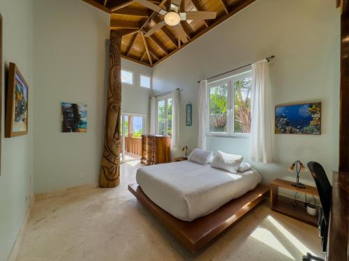 a bedroom with a white bed and a window at Belizean Cove Estates Beachfront Villas in San Pedro
