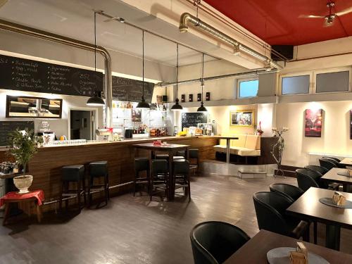 a restaurant with a bar and tables and chairs at Hotel BernsteinSee in Bitterfeld