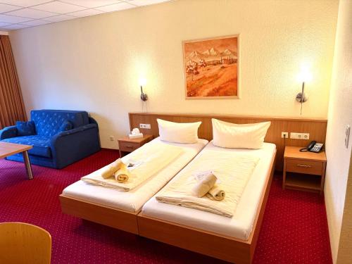 a hotel room with a bed and a blue chair at Hotel BernsteinSee in Bitterfeld