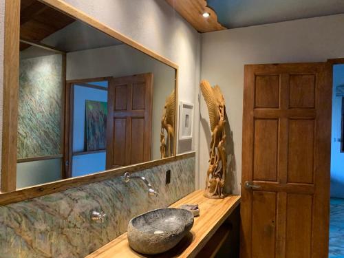 een badkamer met een stenen wastafel en een spiegel bij Frondavista San Pancho in San Francisco