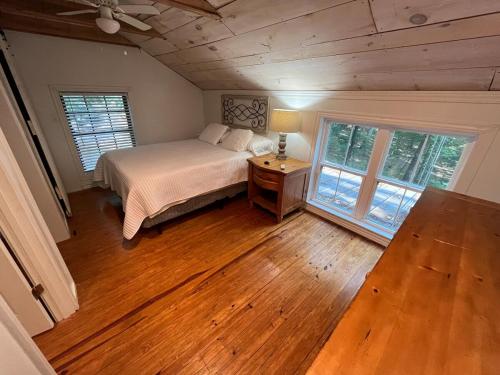 a bedroom with a bed and a wooden floor at Cozy Cabin near KentuckyLake in Murray