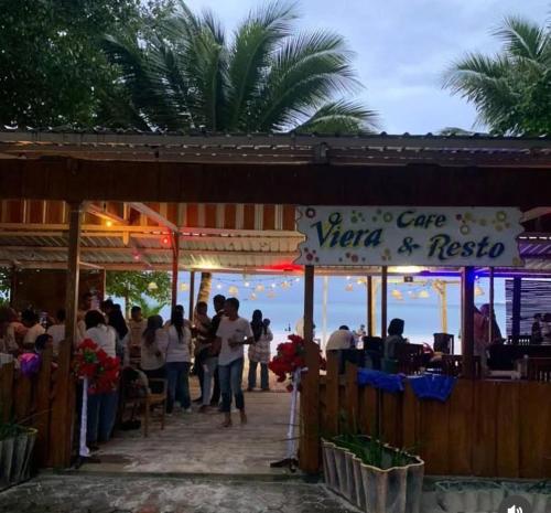 a group of people standing outside of a cafe near the ocean at Viera Resort in Ngurblut