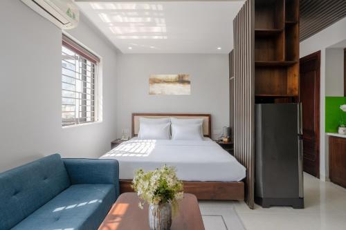 a bedroom with a bed and a blue couch at LUMIS TOURANE Hotel in Da Nang