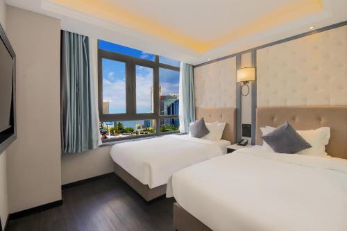 two beds in a hotel room with a window at WangfujingXiyuanHotel Central Beijing in Beijing