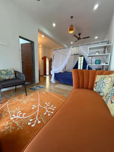 a living room with a bed and a couch at Sandbox in Malvan