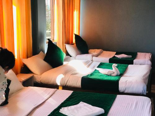 een kamer met drie bedden met zwanen erop bij Mita Hotel in Dhulikhel