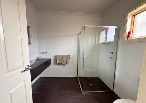 a bathroom with a shower and a sink at Sundowner Motel Hotel in Whyalla