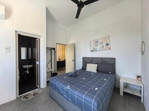 a bedroom with a blue bed and a bathroom at Langkawi Simfoni Lavanya Suite 13 in Kuah