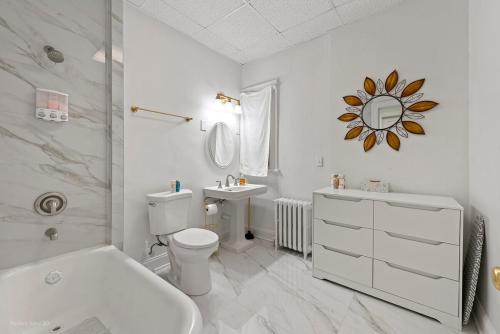 a white bathroom with a toilet and a sink at The Palace in Rockford