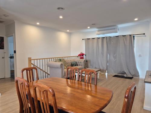 a dining room with a wooden table and chairs at Sredna Homestay in Braybrook