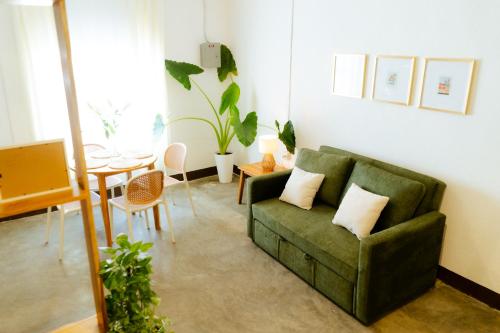 ein Wohnzimmer mit einer grünen Couch und einem Tisch in der Unterkunft Casa Ramona in Flores