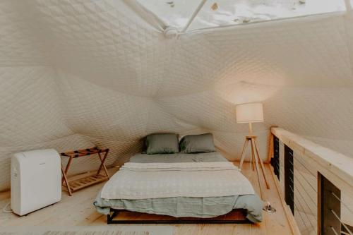 een slaapkamer met een bed in een witte tent bij The Perch Glamping by Rafting in Cosby