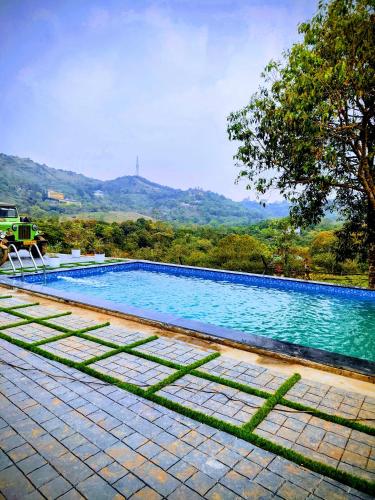 a swimming pool with a view of a mountain at Wantara Villa in Vagamon