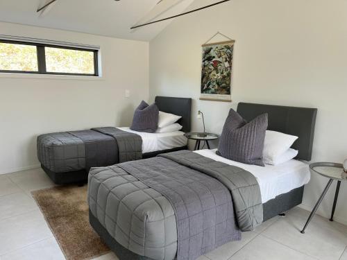 een slaapkamer met 2 bedden en een tafel bij Windhover Estate in Tasman