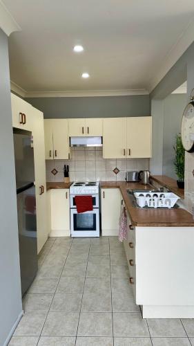 a kitchen with white cabinets and a stove top oven at Home away from home! in Liverpool