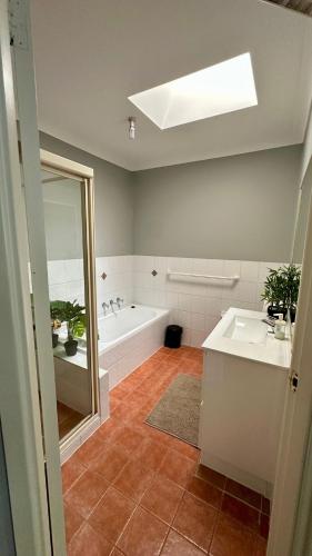 a bathroom with a tub and a sink and a mirror at Home away from home! in Liverpool