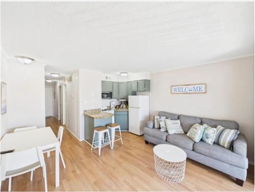 a living room with a couch and a table at Galveston condo- walk to beach - ocean view - 2 pools in Galveston