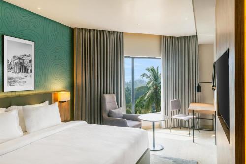a hotel room with a bed and a desk at Park Inn & Suites by Radisson, Puri in Puri