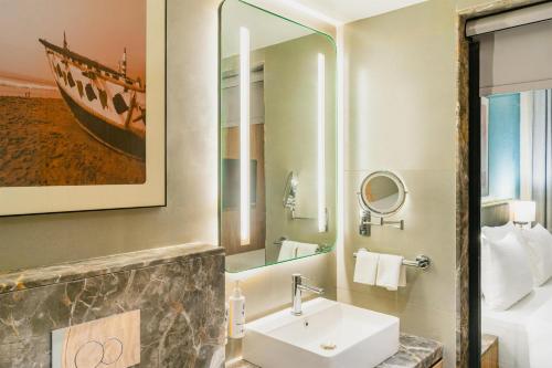 a bathroom with a sink and a mirror at Park Inn & Suites by Radisson, Puri in Puri