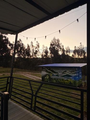 a covered deck with a building with a painting on it at Sendero Nativo Glamping in Monguí