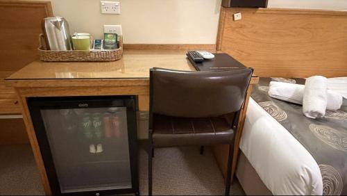 una scrivania con computer portatile e sedia accanto a un letto di Campbell st Lodge a Castlemaine