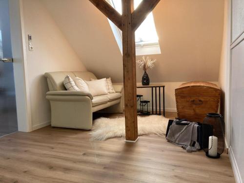 een woonkamer met een bank en een houten paal bij Gipfelglueck-bei-der-Purpurbuche in Bad Harzburg