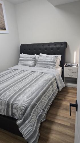 a bed with a black headboard in a bedroom at Elian's Nest in Saskatoon