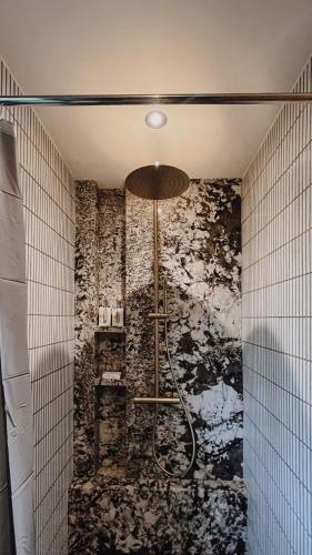 a bathroom with a shower with a stone wall at Wanagiri Cabin Wanara in Gitgit