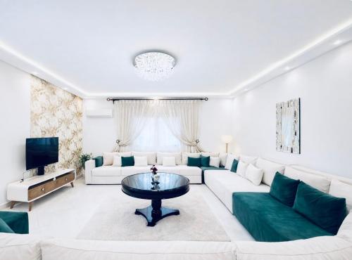 een woonkamer met een witte bank en een tafel bij Luxury Villa with Pool & Garden5km from Cabo in Tetouan