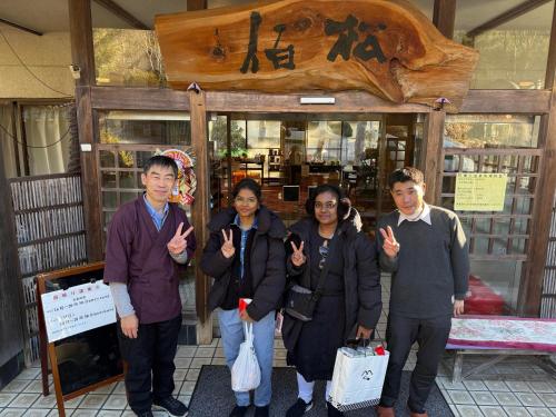 a group of people standing in front of a store at 檜湯の宿　松伯 in Aoki-gemi