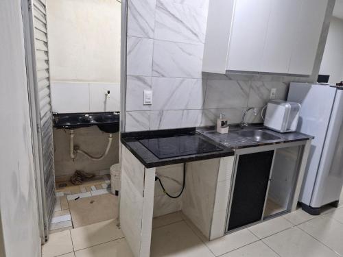 a small kitchen with a sink and a refrigerator at Próximo a roda gigante in Maceió