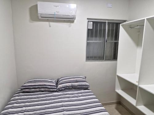a small bedroom with a bed and a heater at Próximo a roda gigante in Maceió