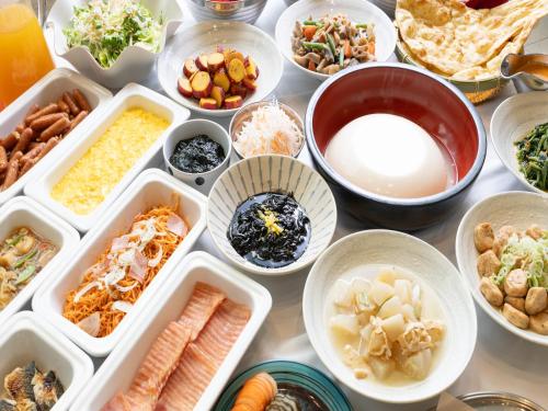una tabella piena di diversi tipi di alimenti in ciotole di APA Hotel Toyama Ekimae a Toyama