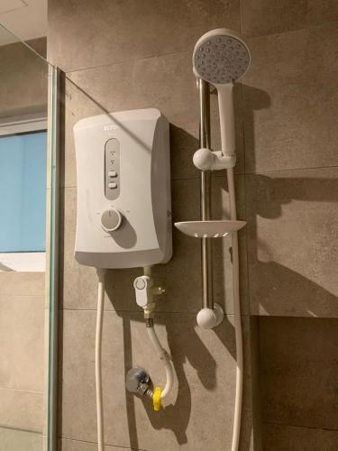 a shower in a bathroom with a shower head at Ezhome Mesahill in Nilai