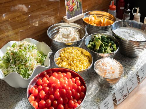 una tabella ricoperta di ciotole di diversi tipi di alimenti di APA Hotel Toyama Ekimae a Toyama