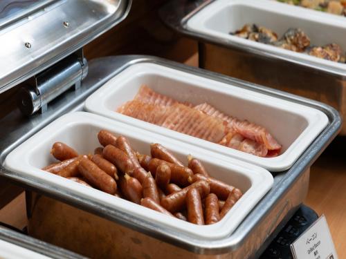 un vassoio di hot dog e pesce su un bancone di APA Hotel Toyama Ekimae a Toyama