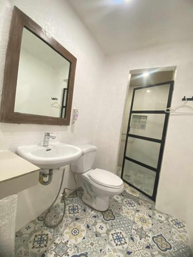 a bathroom with a toilet and a sink and a mirror at Baluarte Rest and Relaxation in Sampong