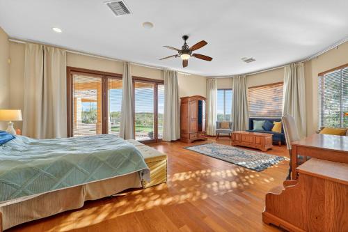 a bedroom with a bed and a desk and windows at AUTHENTIC SANTA FE STYLE VILLA WITH PANORAMIC VIEWS in Gold Canyon