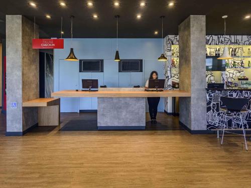 Una donna seduta a una scrivania in un ufficio con un portatile di ibis Guaiba a Guaíba