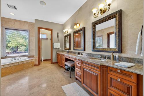a bathroom with two sinks and a tub and a mirror at AUTHENTIC SANTA FE STYLE VILLA WITH PANORAMIC VIEWS in Gold Canyon